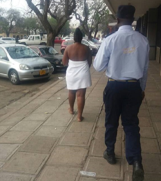 Conned woman strips naked. . . Women form human shields hide her nakedness