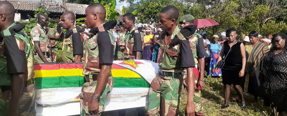 Pallbearers carry the casket with Cde Gumbo's body to his final resting place