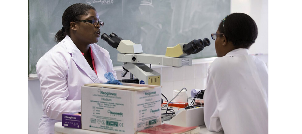 An instructor and student share a teaching microscope at Africa University.— Picture: Mike DuBose, UM News