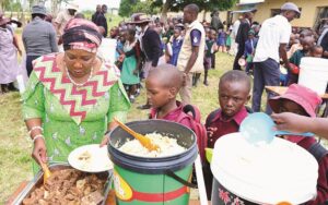 First Lady Dr Auxillia Mnangagwa serves food to children during one of her countless school feeding programmes around Zimbabwe