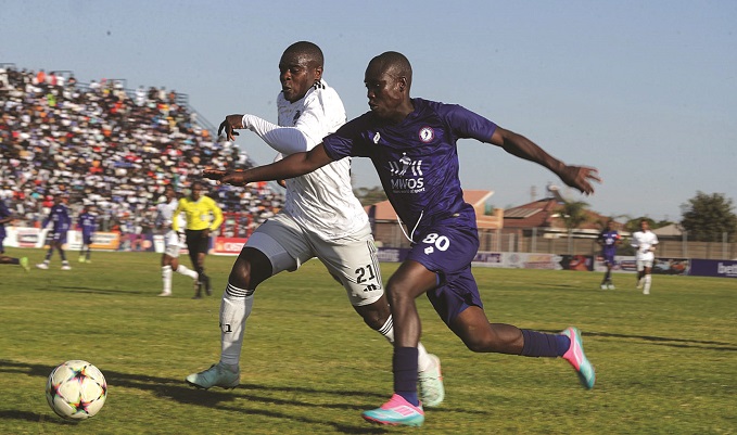 THE RACE IS ON . . . MWOS winger Tafadzwa George (right) and Scottland defender Godknows Murwira charge for the ball during yesterday’s match at Ngoni Stadium. — Picture: Kudakwashe Hunda