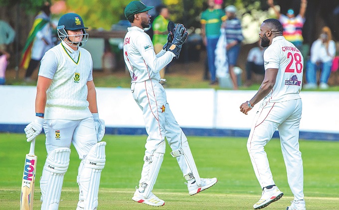 HOWZ THAT . . . Seamer Tanaka Chivanga (right) and wicketkeeper Tafadzwa Tsiga (centre) celebrate the dismissal of Lhuan-dre Pretorius during the first day of the first Test between Zimbabwe and South Africa at Queens Sports Club yesterday