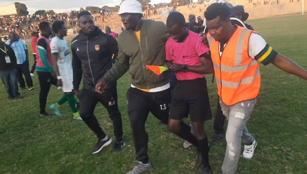 Second assistant referee Kuda Marange being escorted off the field after the league match between Manica Diamonds and CAPS United at Sakubva on Saturday. - Picture: Moffat Mungazi