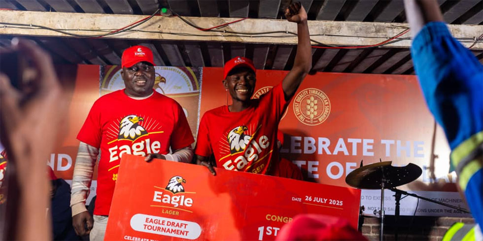 Delta Beverages official Tapiwa Munyonga (left) hands over the first position prize to the winner Bret Muteedzi