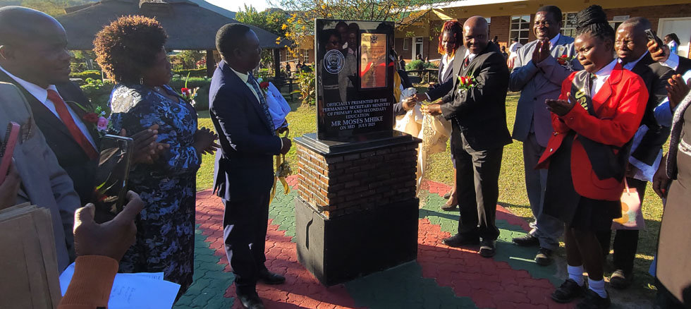Primary and Secondary Education Permanent Secretary, Mr Moses Mhike (right) unveils the Secretary Bell’s Merit Award plaque awarded to First Class High School in Fern Valley last week
