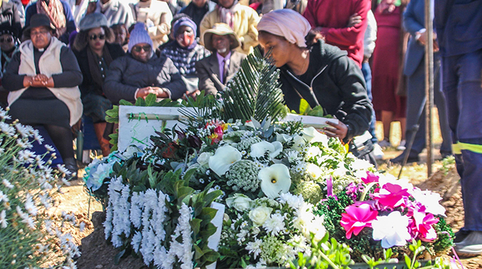 Close relatives and family lay bouquets of flowers on the grave of the now late academic Professor Bubuya Masola at Lady Stanley cemetery in Bulawayo yesterday morning.-Picture:Joshua Muswere
