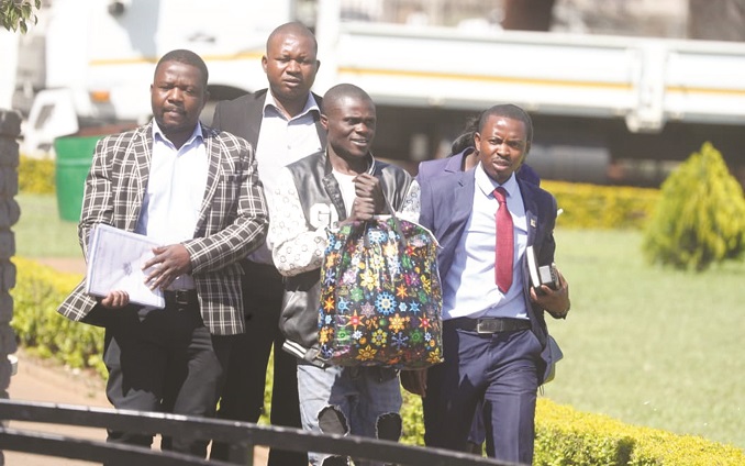 John Chagwiza (second right) appeared at Harare Magistrates Courts yesterday facing four counts of robbery after he allegedly stole cellphones, laptops and cameras, among other items, worth US$8 600 in Borrowdale, Harare