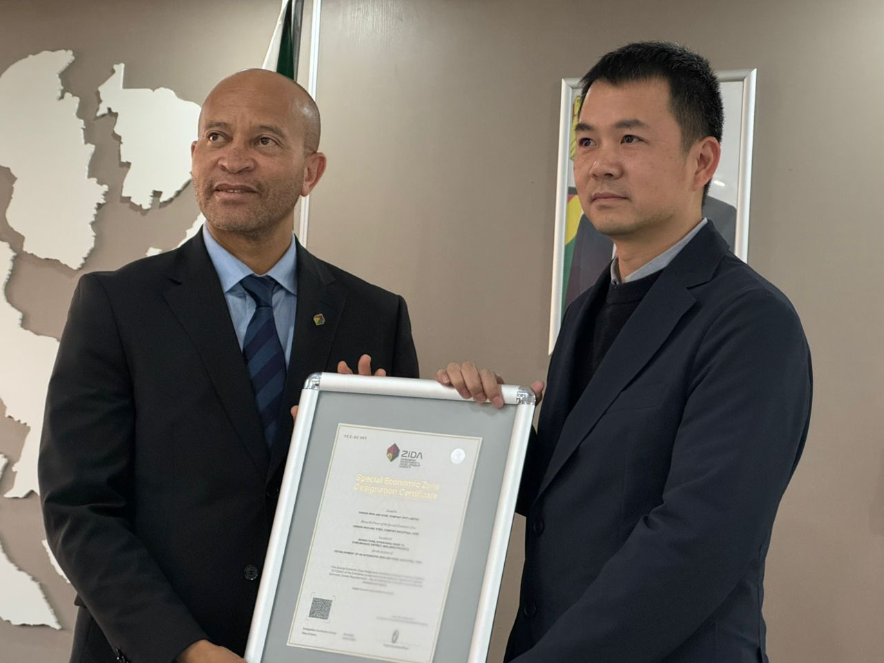 Zimbabwe Investment and Development Agency (ZIDA) chief executive Mr Tafadzwa Chinamo hands over the SEZ certificate to Mr Benson Xu
