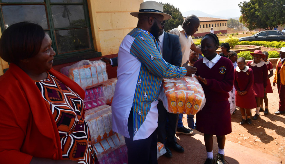 Minister Mugadza hands over the sanitarywear to one of the learners