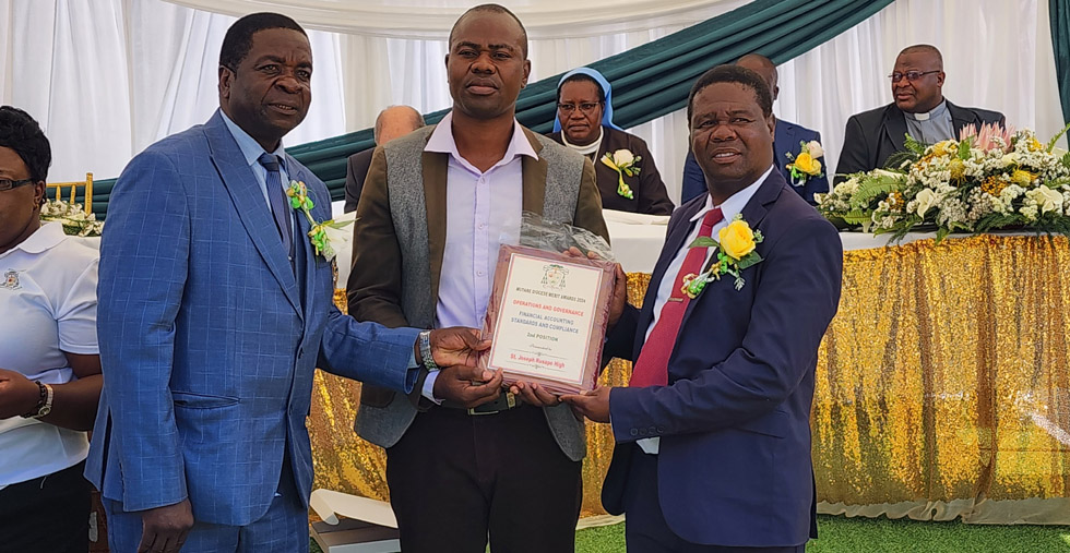Manicaland Provincial Education Director, Mr James Gabaza presents an award to St Joseph’s Rusape High School head, Mr Stanley Makota (right) and the SDC chairman, Mr Evans Majoni