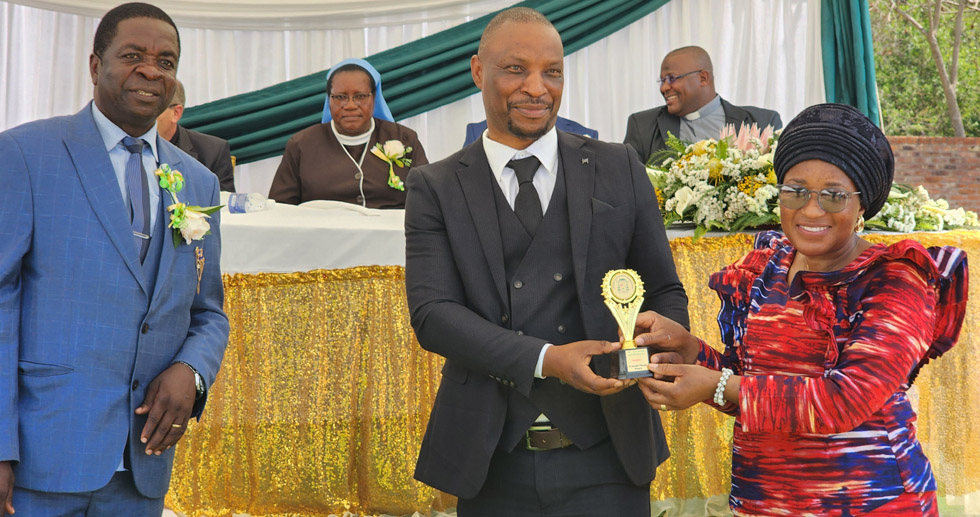 Mt Mellary Primary School head, Mr Blessing Jeyacheya (centre) and a member of the SDC with one of the awards which the school scooped
