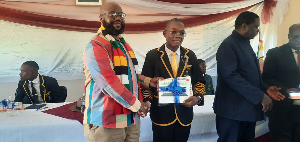 Minister Misheck Mugadza handsover a tablet to the Junior Minister of Skills Audit and Development, Honourable Nikki Manunure