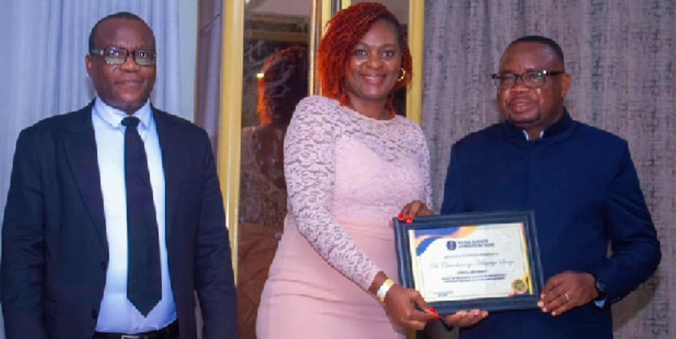 Dr Chido Sango (centre) receives her award from Skills Audit and Development Minister, Professor Paul Mavima (right)