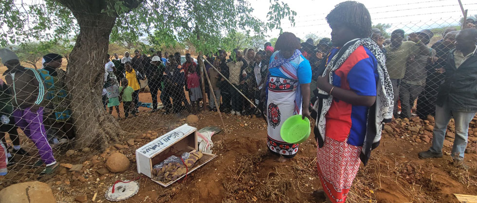 The two traditional healers opened the small coffin before sprinkling petrol and burning it