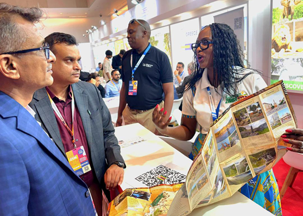 Ministry of Tourism and Hospitality attaché based in India, Mrs Sophie Chimba, chats with some visitors who passed by the stand