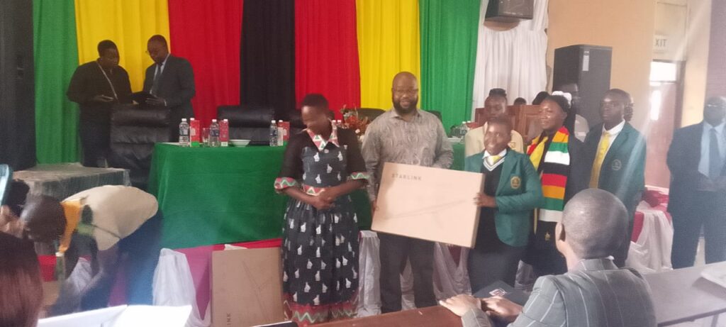 Minister of State for Provincial Affairs and Devolution, Advocate Misheck Mugadza hands over a Starlink kit to junior parliamentarians this morning at Mutare Teachers College