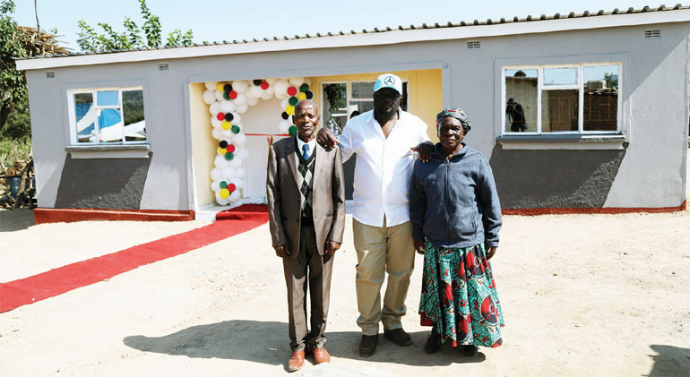 Madzibaba Deminase poses for a picture with Mr and Mrs Samhiri at their new house