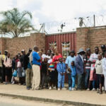 Long queues form outside the stadium as large numbers of supporters attempt to gain entry without paying