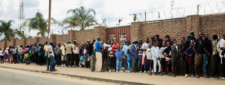 Long queues form outside the stadium as large numbers of supporters attempt to gain entry without paying