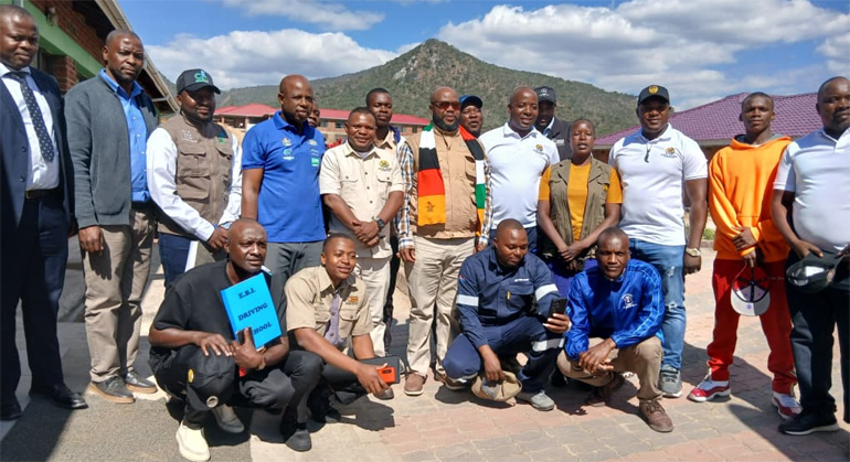 Minister Misheck Mugadza (centre, with a scarf) flanked by the young miners