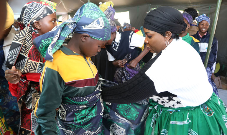 Culture and Heritage Ambassador First Lady, Dr Auxillia Mnangagwa teaches a young girl how to wrap a zambia during a Nhanga session at the Boys and Girls Mentorship Camp in Nyanga, promoting cultural heritage and preservation of traditional customs among the younger generation. - Pictures: Justin Mutenda