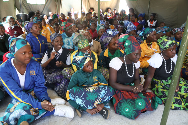 Primary school girls listen attentively to advice from the First Lady and elderly women during a nhanga session at the Boys and Girls Mentorship Camp, where they receive guidance on values, life skills, and cultural traditions