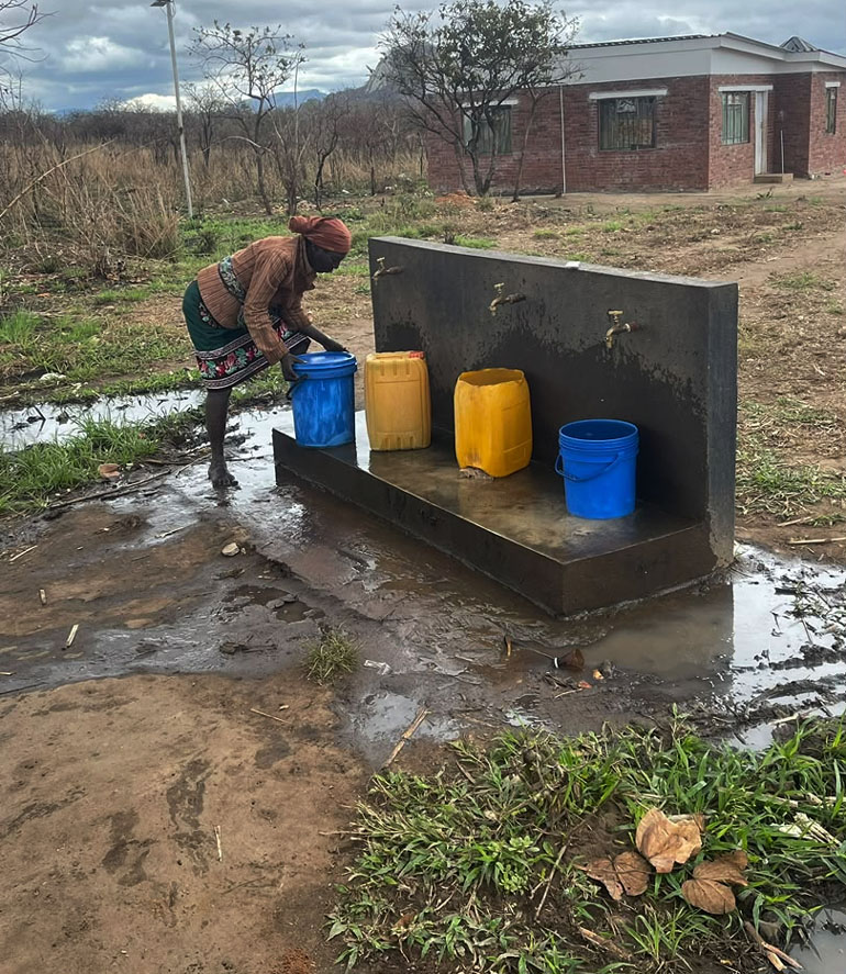 A villager collects water from the newly installed solar-powered reticulated water system at Chimoio Shrine in Mozambique. The project has improved access to clean water for communities living around the historic liberation heritage site