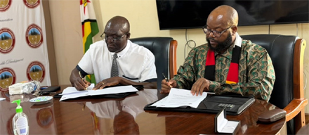 Minister Mugadza (right) and Professor Chawanda sign the MoU