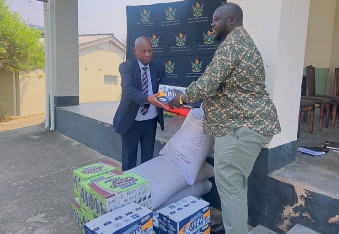 Public Service, Labour and Social Welfare Minister, Honourable Edgar Moyo hands over groceries to the home's director, Mr William Pepukai