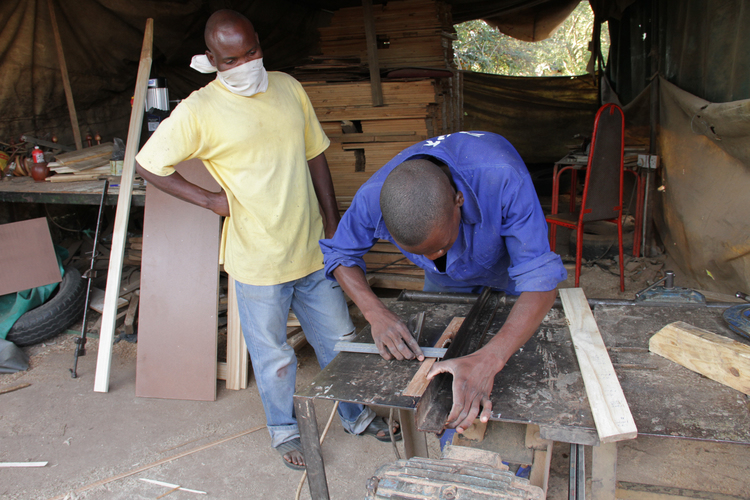 Mr Edson Chimombe (standing) supervises one of his workers
