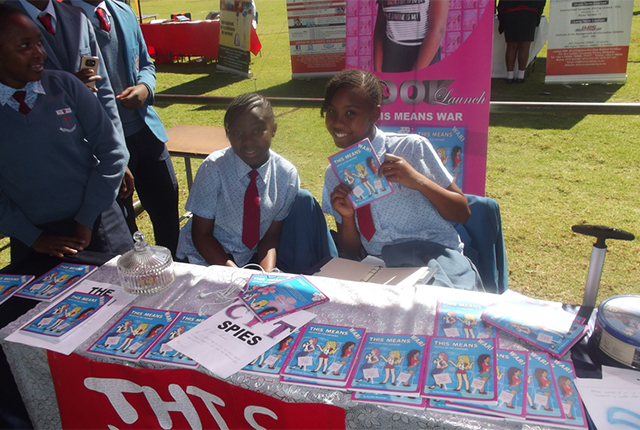 Rumbidzodzashe Munembe (centre) exhibits copies of her book