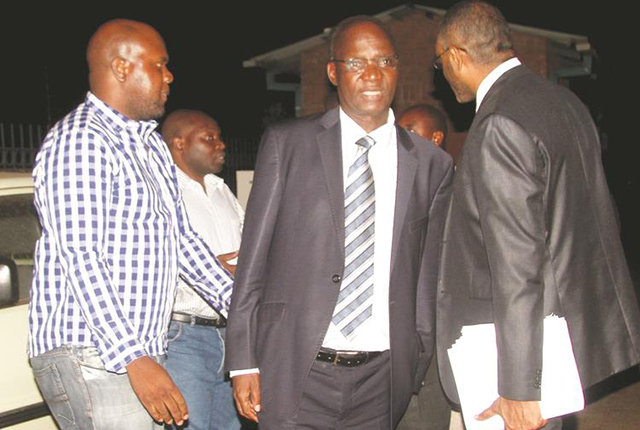 Higher and Tertiary Education, Science and Technology Development Minister Professor Jonathan Moyo speaks to his lawyer Mr Terrence Hussein (right) and son-in-law Tafadzwa Wakatama (left) at the Zimbabwe Anti-Corruption Commission offices in Mt Pleasant, Harare, yesterday evening