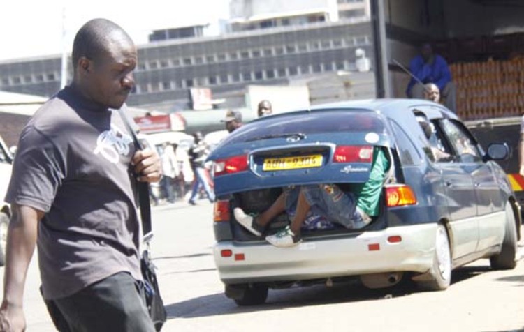 PASSENGER SITTING PRECAURIOUSLY IN AN IPSUM ALONG CHINHOYI STREET 