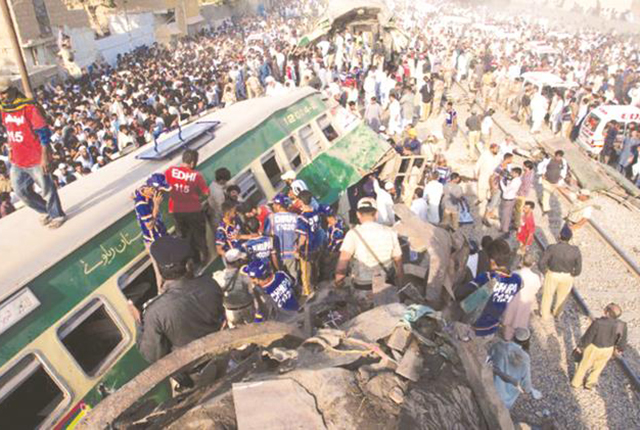 Bystanders search the wreckage for victims of a train crash in Karachi, Pakistan, which killed 21 and injured another 65 during yesterday morning’s rush hour. -CNN