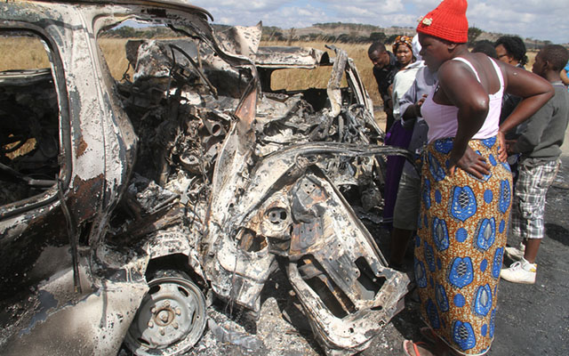 (Right) People mill around the wreckages of the burnt Nissan Caravan and Honda HR-V that were involved in a head-on collision and caught fire (left) along Mvurwi-Centenary highway recently