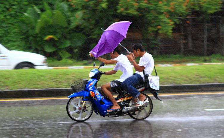 Just appreciate the humour . . . Drive fast on a wet road, with no helmet, often with one hand only, the other hand is holding an umbrella against the wind. Anyway, with the rain in your face, you can’t really open your eyes, can you?