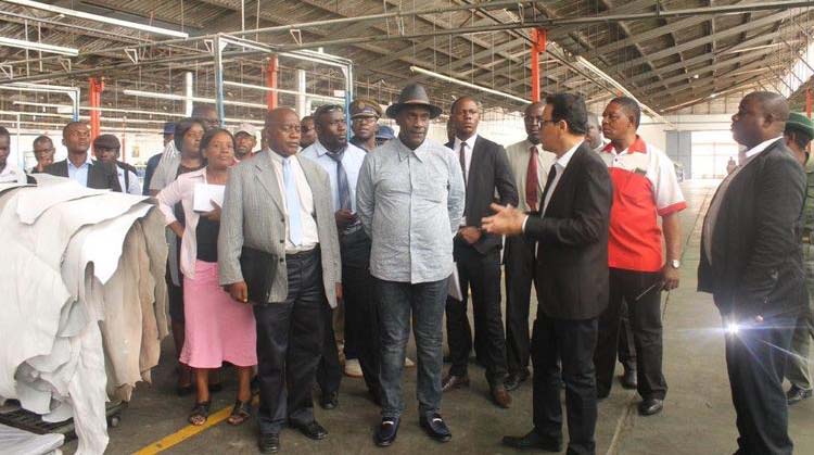 Bata Shoe Company managing director Mr Ehsan Zaman explains to the Midlands Minister of State for Provincial Affairs Cde Owen Ncube (wearing hat) the shoe production process at the factory in Gweru yesterday