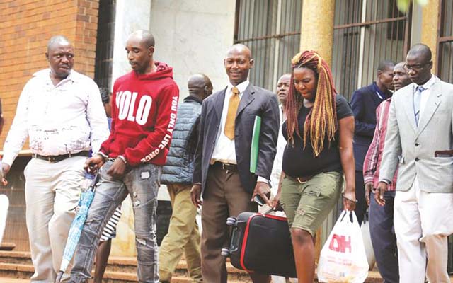 Police detectives lead suspected Command Agriculture inputs thief into the Harare Magistrates’ Courts for Friday’s hearing. — (Picture by Lee Maidza)