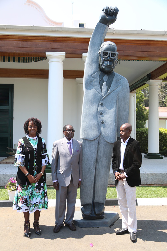President Mugabe and First Lady Amai Grace Mugabe pose for a picture with sculptor Dominic Benhura on one of the statues presented at State House in Harare yesterday. — Picture by Believe Nyakudjara