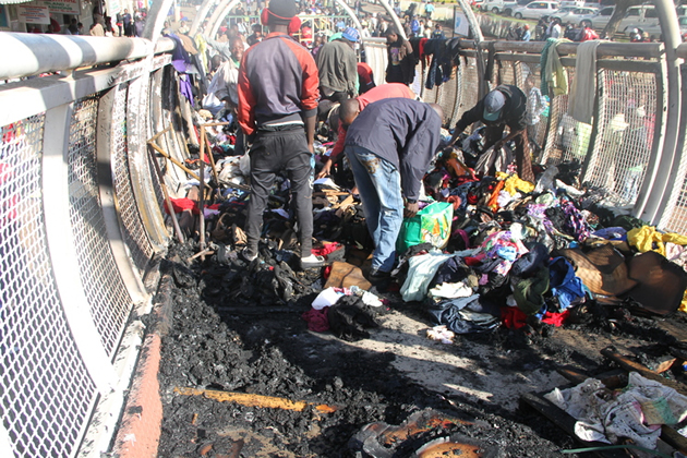 Vendors sift through remnants of their clothing bales which went up in smoke early yesterday morning following a suspected arson attack