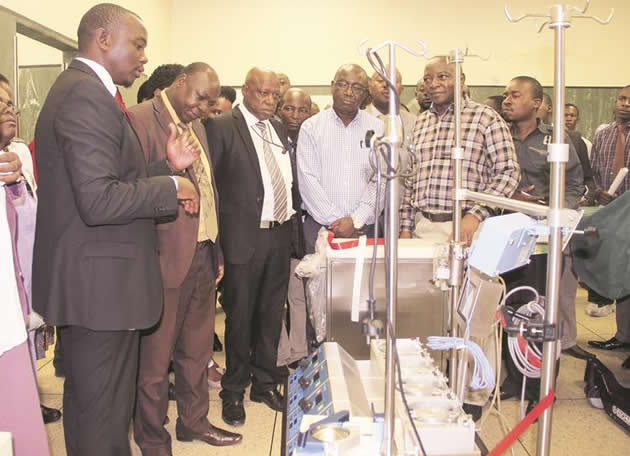 Health and Child Care Deputy Minister Aldrin Musiiwa (second from left) commissions open heart surgery equipment while Sub Sahara Africa Structural Heart Manager Sihe Mlambo, cardiovascular specialist (left) explains how the machine works. Looking on are officials from Parirenyatwa Group of Hospitals. — Picture by Memory Mangombe