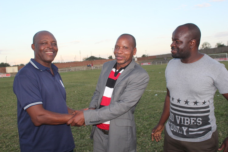 JOB WELL DONE . . . ZPC Kariba coach Sunday "Mhofu" Chidzambwa (left) is congratulated by Kariba Member of Parliament Isaac Mackenzie while fans Phineas Nyamunga joins the fun at Nyamhunga on Thursday after the victory over champions CAPS United. - Picture by Paul Mundandi