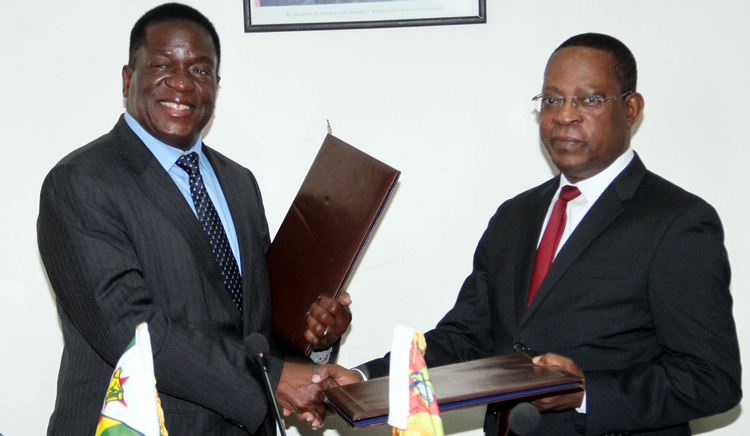 Vice President responsible for the Justice, Legal and Parliamentary Affairs portfolio Cde Emmerson Mnangagwa exchanges MOU documents on the transfer of offenders between Zimbabwe and Mozambique with his Mozambican counterpart Honourable Isaque Chande in Harare yesterday. — (Picture by John Manzongo)