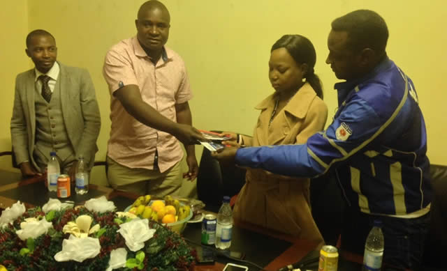 Killer Zivhu (second left) and Suluman Chimbetu (right) hand over air tickets to Mollen Makoni while Mathias Mhere (left) looks on