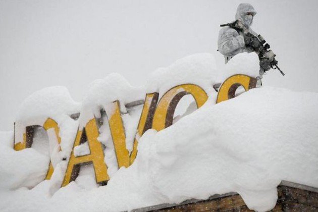 An armed security personnel wearing camouflage clothing stands on the rooftop of a hotel, next to letters covered in snow reading “Davos”, near the Congress Centre during the opening of the 2018 World Economic Forum (WEF) annual summit in Davos. — AFP