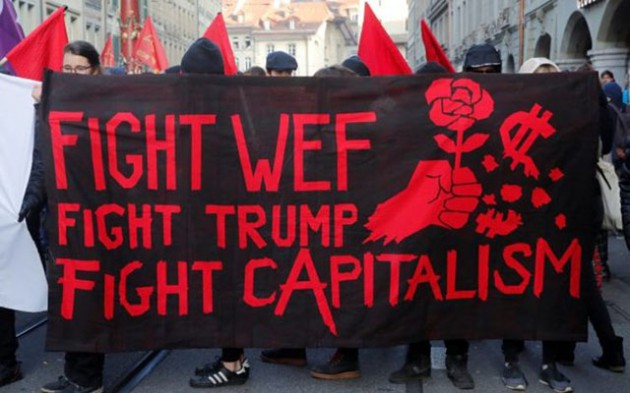Protesters with banners march during an anti-World Economic Forum and anti-U.S. President Donald Trump demonstration