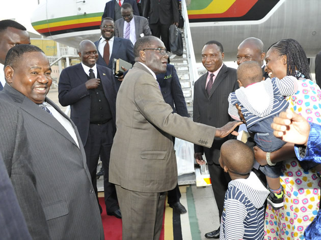 President Mugabe greets Zimbabwe embassy staff at Maputo International Airport while Ambassador to Mozambique Nicholas Dube (left) looks on