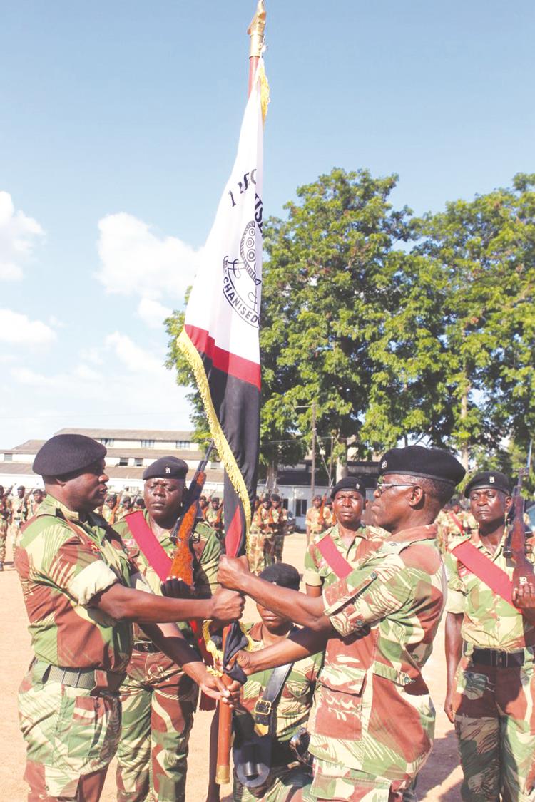 1 Mechanised Battalion Outgoing Commanding Officer Lt-Col Enerst Dube (Right) hands over the battalion flag to incoming Commanding Officer Lt-Col Colleen Mafika at a handover-takeover ceremony held on Wednesday at One Mechanised Brigade, Inkomo. — (Picture by Nyasha Chawatama)