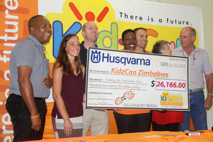 KidzCan founder Andrea Whatman (second from right) flanked by the company's board chairman Dave Willis (far right), Advocacy and Fundraising Officer Maureen Maradzika (centre), Husqvarna Events Director Grant Mitchell (third from right), Cutting Edge General Manager Alec Philip (third from left), Husqvarna Marketing Manager Erin de Jesus (second from left) and Kidzcan acting director Daniel Mckenzie during the handover of a donation from Husqvarna to Kidzcan in Harare yesterday. — Picture by Tariro Kamangira