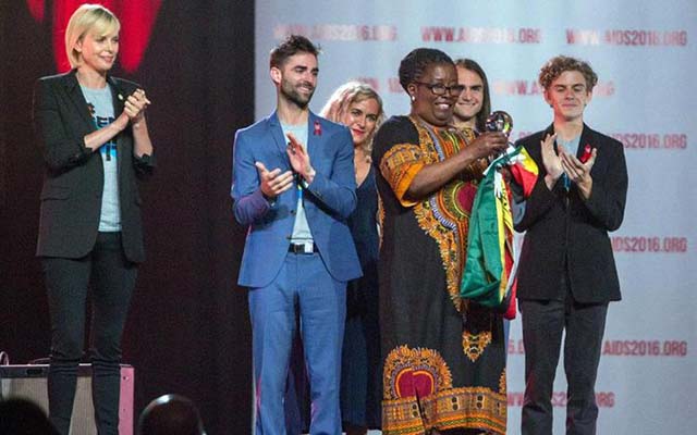 Elizabeth Tailor Human Rights Award winner and HIV activist Ms Martha Tholanah (with Zimbabwean flag) believes the law criminalising wilful HIV transmission stigmatises and discriminates against people living with HIV